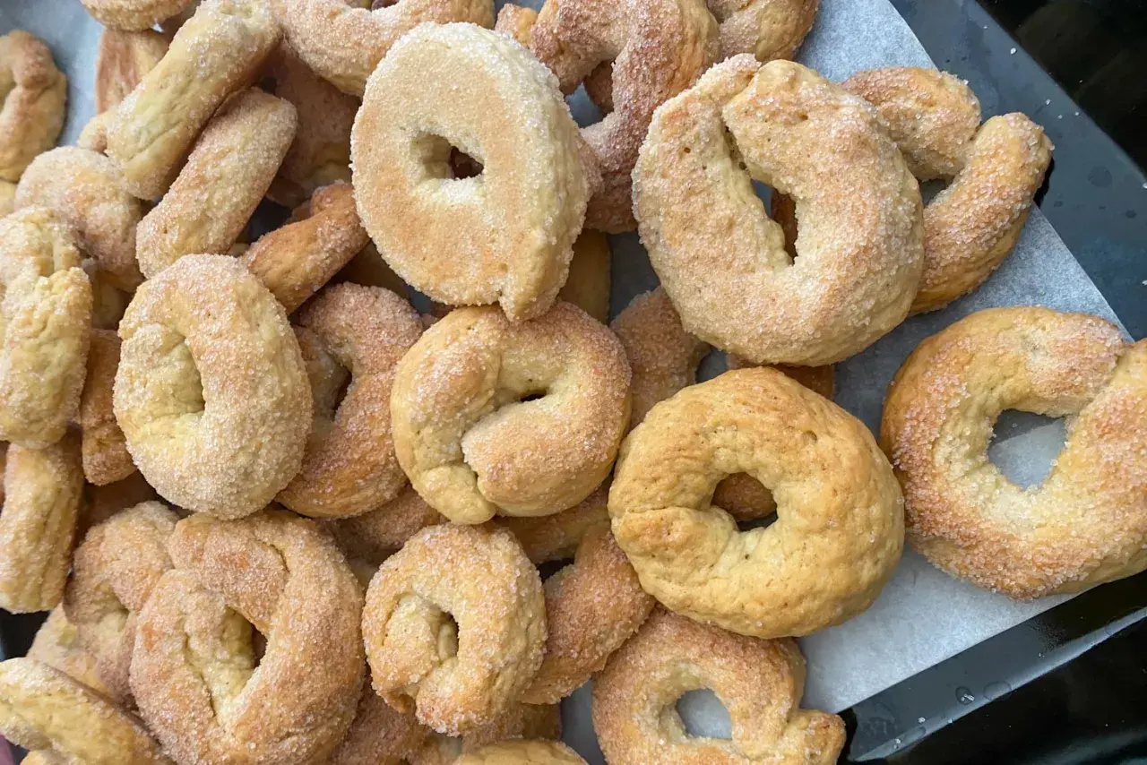 Un mucchio di taralli salati al vino bianco friabili, cosparsi di zucchero, pronti per essere gustati.