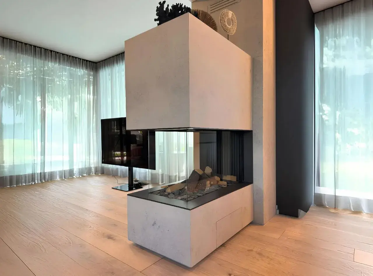 Moderner Kamin Neubau mit Glasfront und Holzelementen, umgeben von hellen Vorhängen und Holzboden.