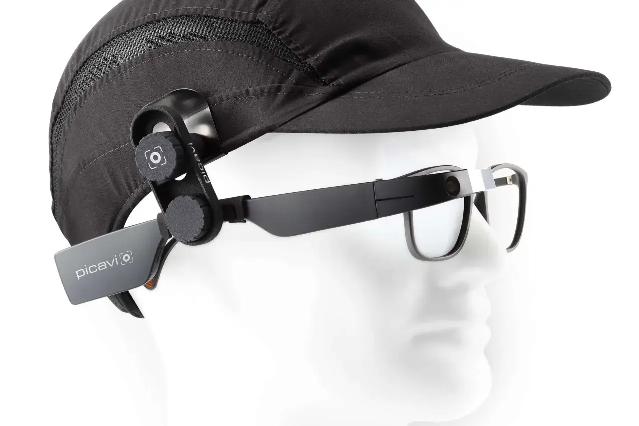 Ein schwarzer Hut mit einer Kamera, die per Vision gesteuert wird, ist an einer Brille befestigt.