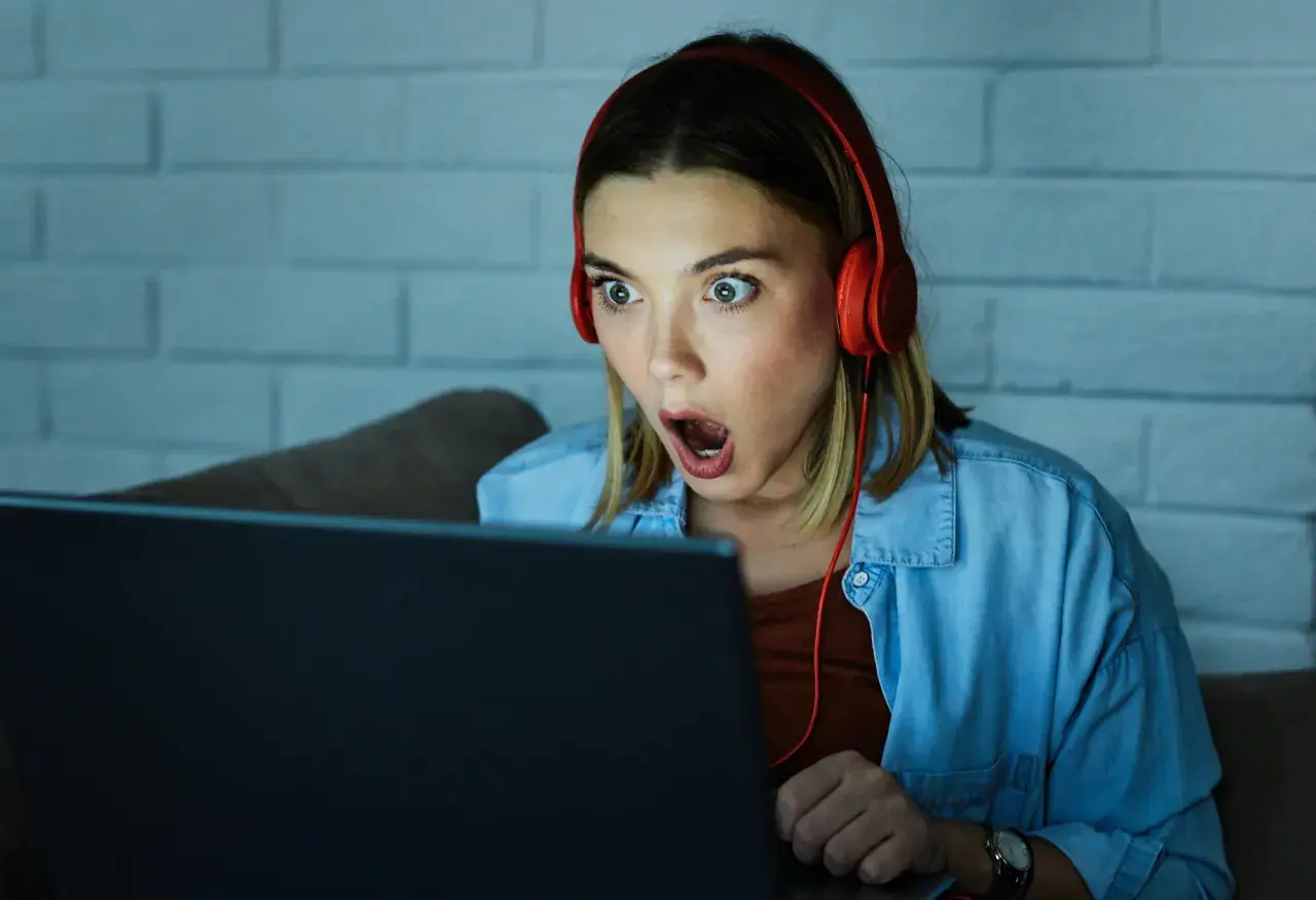 Zaskoczona dziewczyna w słuchawkach gra w escape gry online.