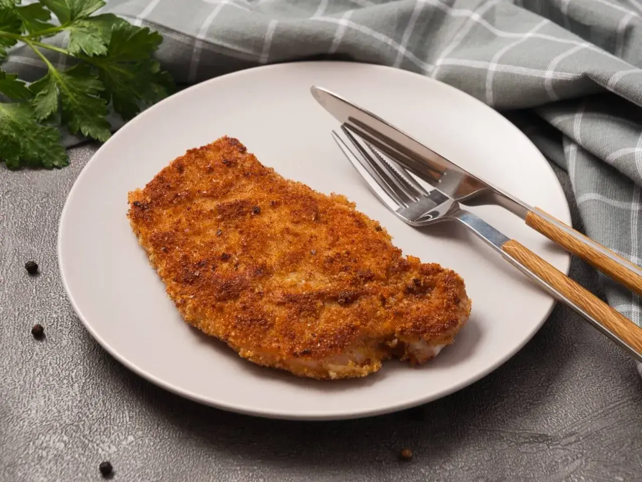 Złocisty kotlet schabowy na talerzu, gotowy do spożycia. Zastanawiasz się nad kotlet schabowy kcal?