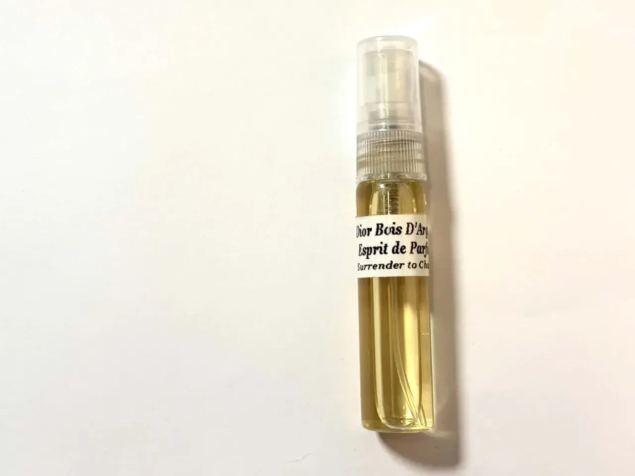 Próbka perfum Dior Bois d'Argent, Esprit de Parfum. Złocisty płyn w szklanej fiolce z atomizerem.