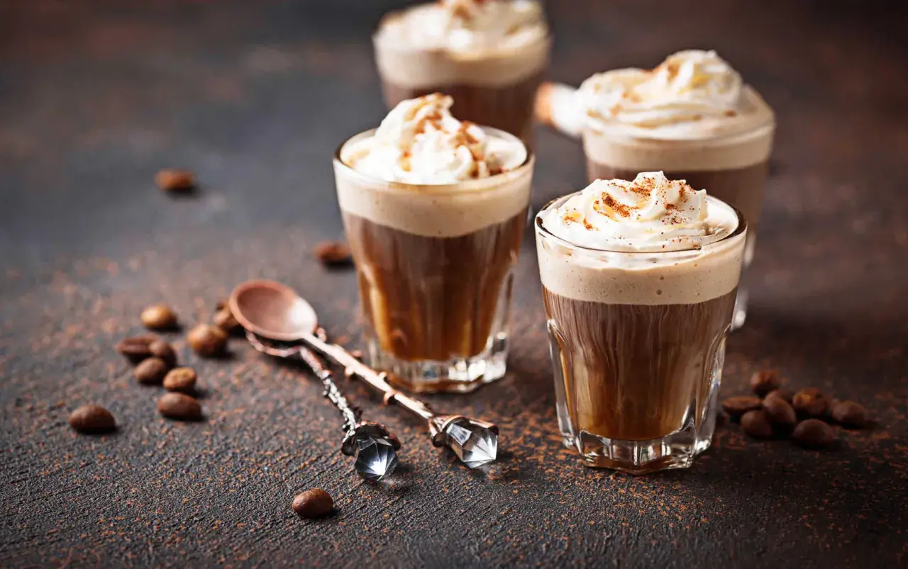 Kawa mocha z ekspresu, udekorowana bitą śmietaną i posypką, prezentuje się apetycznie.