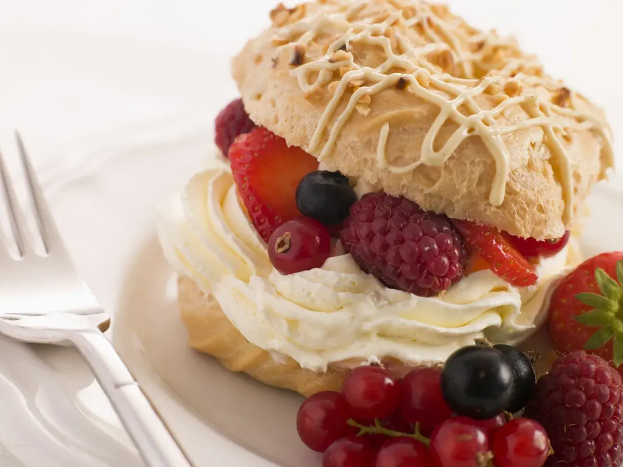 Delizioso pasticcino con chantilly e frutti di bosco freschi, pronto per essere gustato.