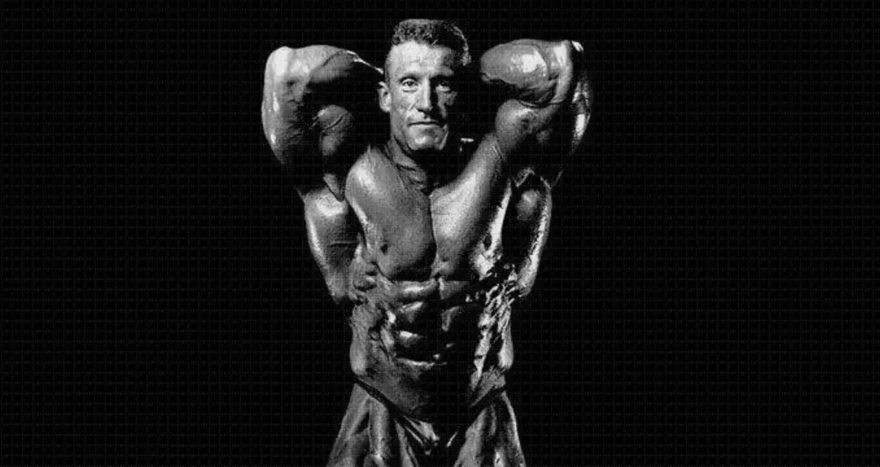 Dorian Yates prezentuje imponującą muskulaturę, dowód ciężkiego treningu.