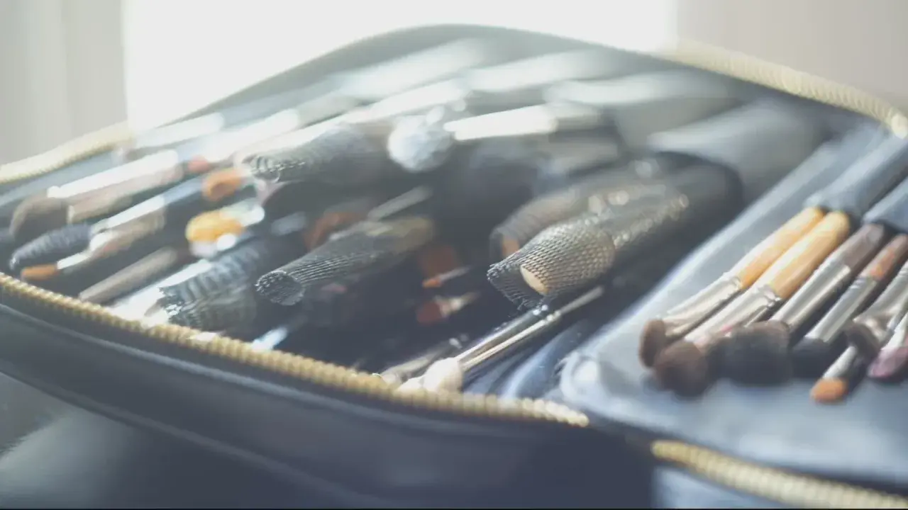 Une trousse ouverte révèle une collection de pinceaux de maquillage, prêts pour un cours de maquillage particulier.