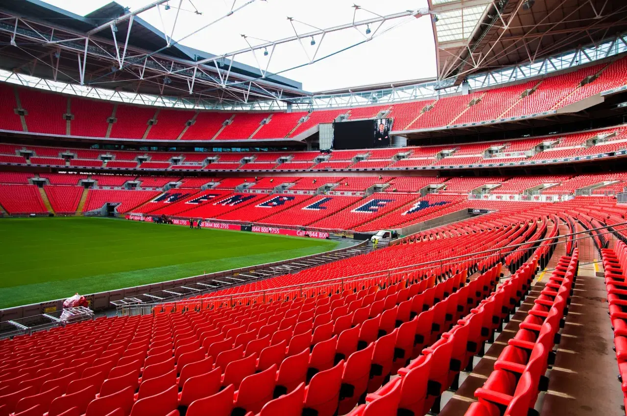 Puste czerwone trybuny jednego z największych stadionów w Anglii, Wembley, czekają na kibiców.