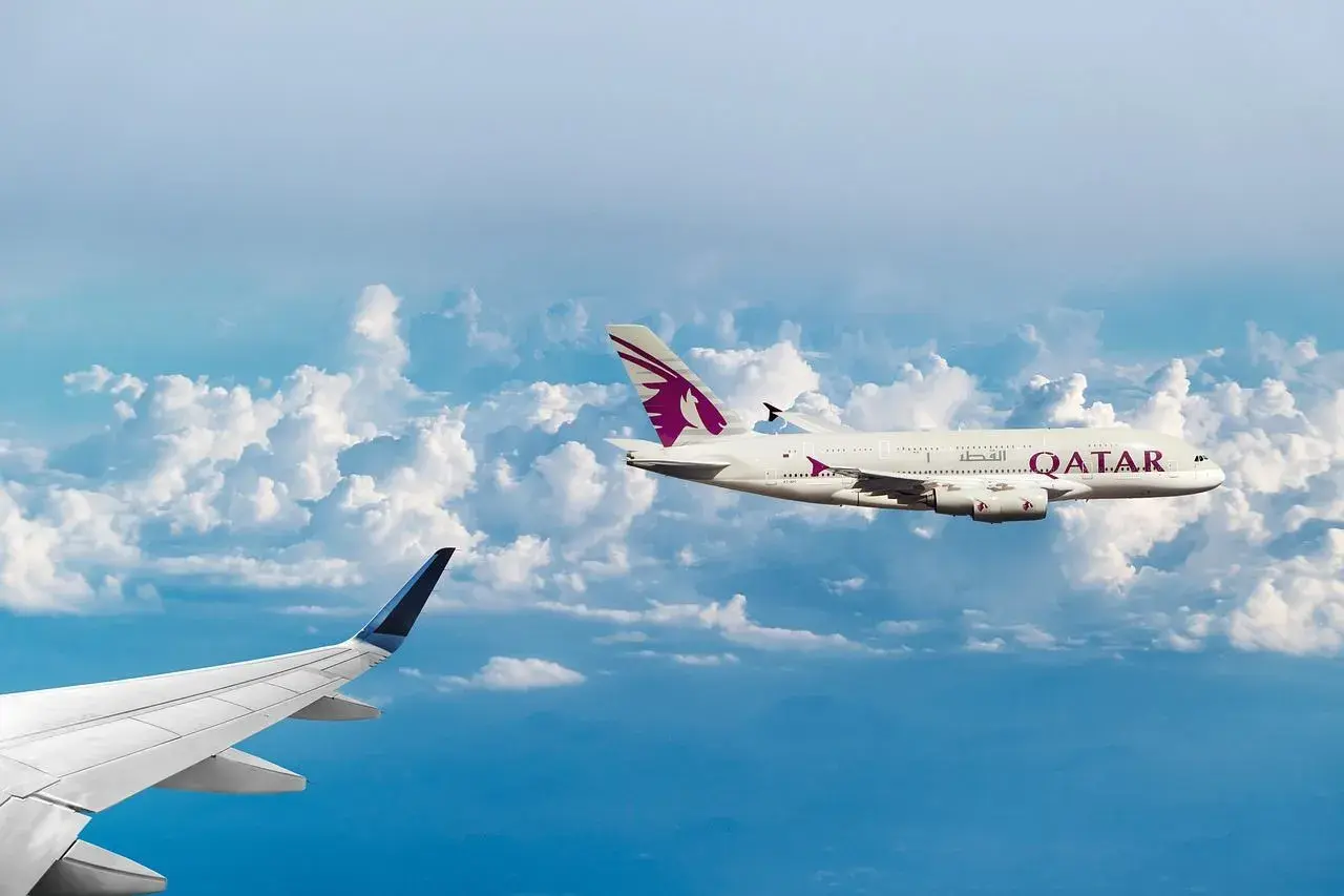 Dwa samoloty pasażerskie lecą nad chmurami. Jeden z nich, z logo Qatar Airways, osiąga średnią prędkość samolotu pasażerskiego.