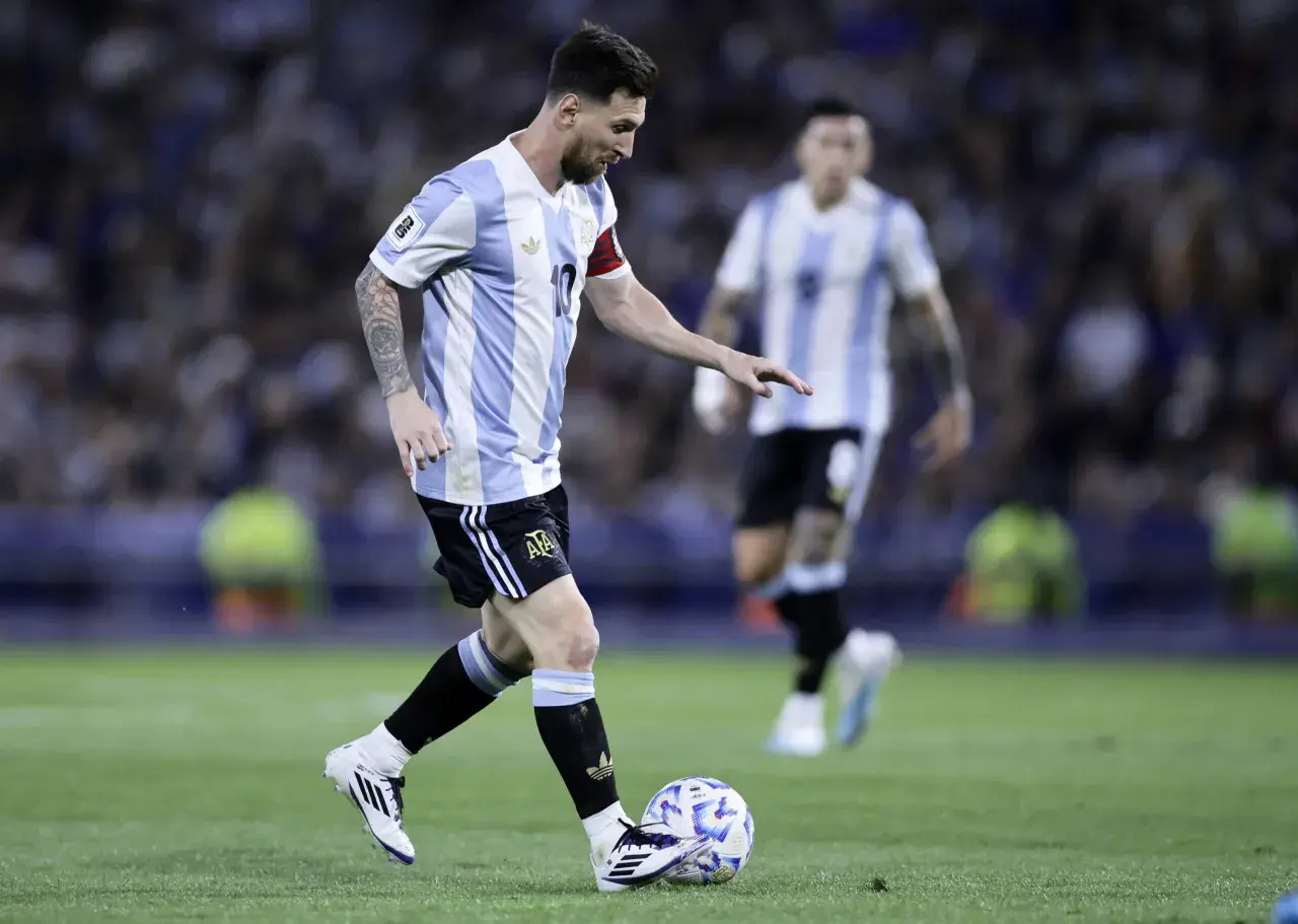 Lionel Messi w koszulce Argentyny prowadzi piłkę. Jego wzrost nie przeszkadza mu w byciu jednym z najlepszych piłkarzy świata.