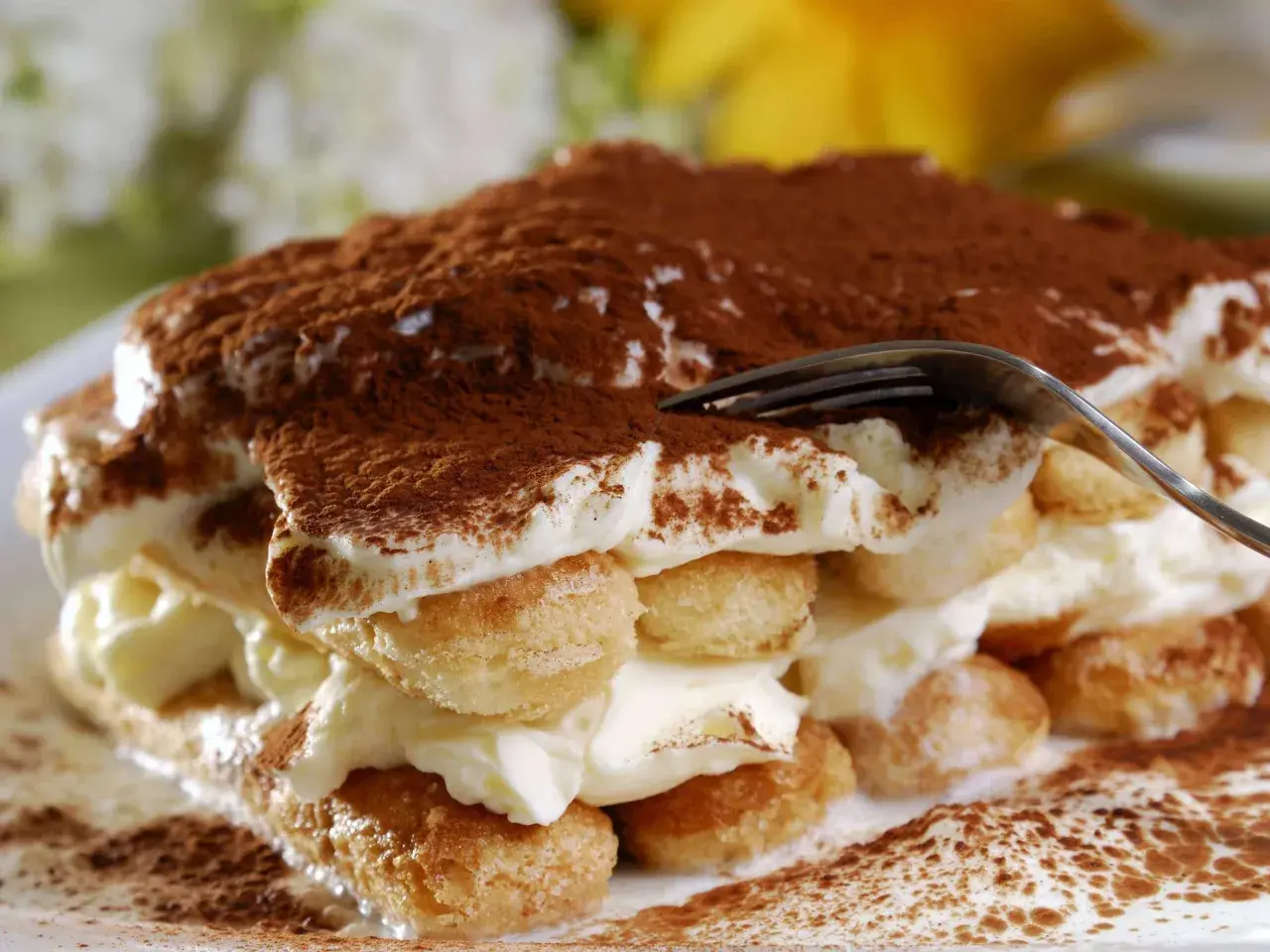 Ein Stück tiramisu originale, mit Löffelbiskuit, Creme und Kakaopulver bestäubt.