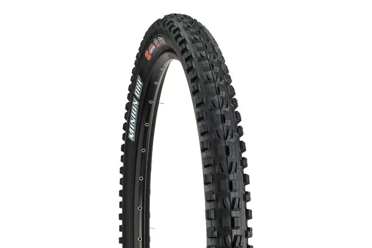 A close-up of a Maxxis Minion DHF tire, ready for a downhill review. Its aggressive tread promises grip.