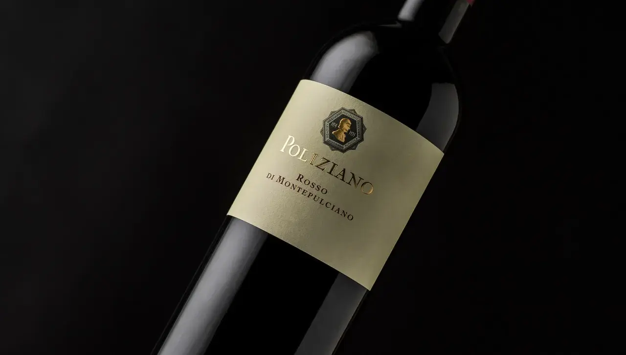 Bottiglia di vino rosso Poliziano, azienda agricola di Montepulciano, con etichetta color crema e scritte dorate.