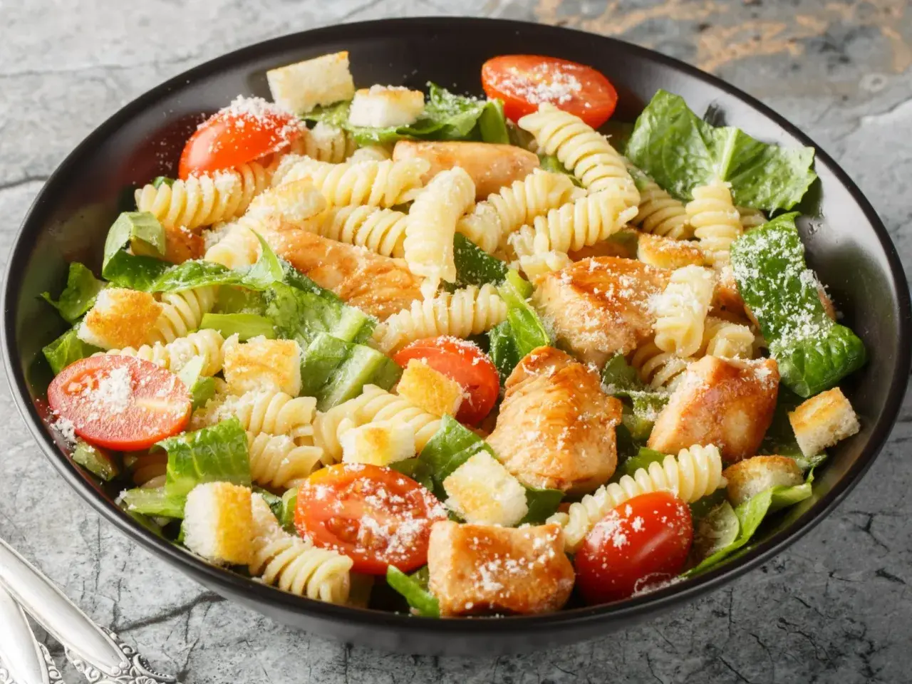 Prosta sałatka z piersią kurczaka, makaronem fusilli, pomidorkami koktajlowymi, grzankami i parmezanem.