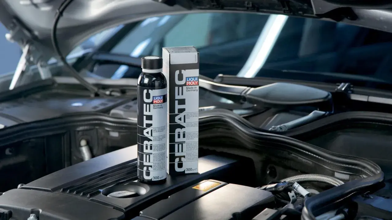 Botella y caja de LIQUI MOLY Cera Tec en un motor. Evita problemas de motor con este aditivo cerámico.