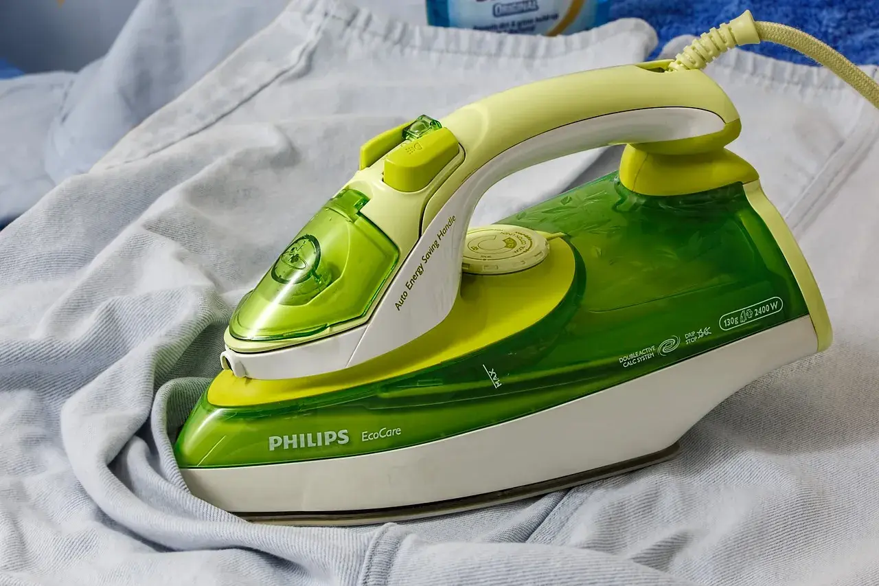 Zielone żelazko Philips EcoCare na jasnych ubraniach. Dowiedz się, jak wyczyścić żelazko, by prasowanie było efektywne.