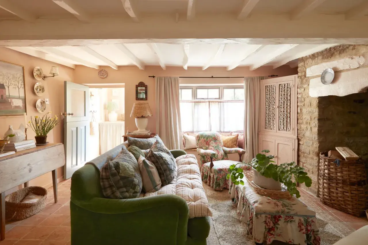 A cozy living room with a green sofa, floral armchair, and a bench, all embodying a charming modern grandma style.