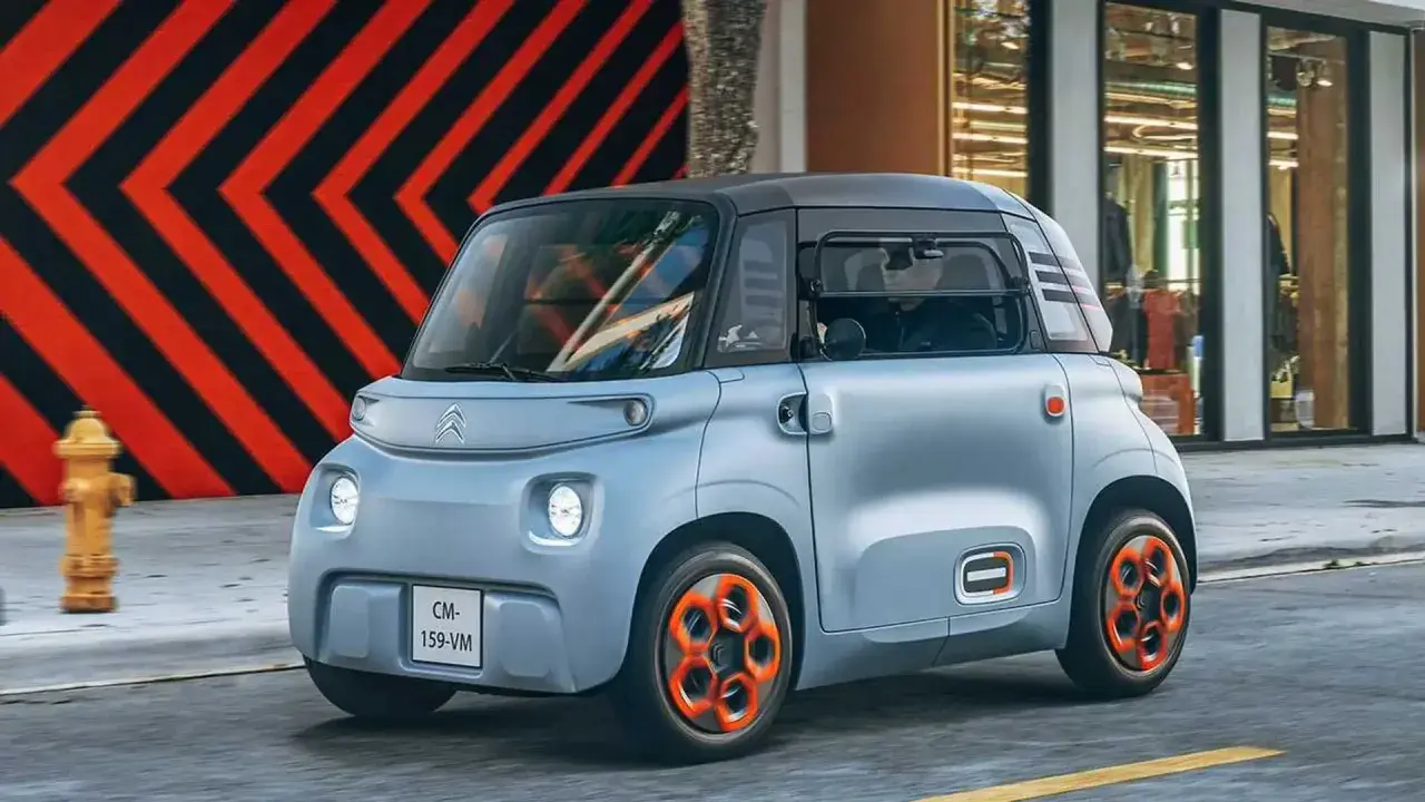 Citroën Ami, un quadriciclo elettrico compatto, sfreccia in città. La sua lunghezza ridotta la rende perfetta per muoversi agilmente nel traffico urbano.
