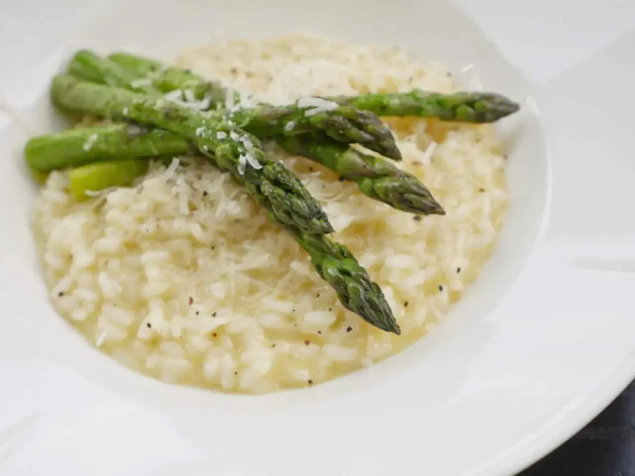 Krämig sparris risotto med toppad med färsk sparris och riven parmesan. En härlig rätt som passar perfekt till våren.