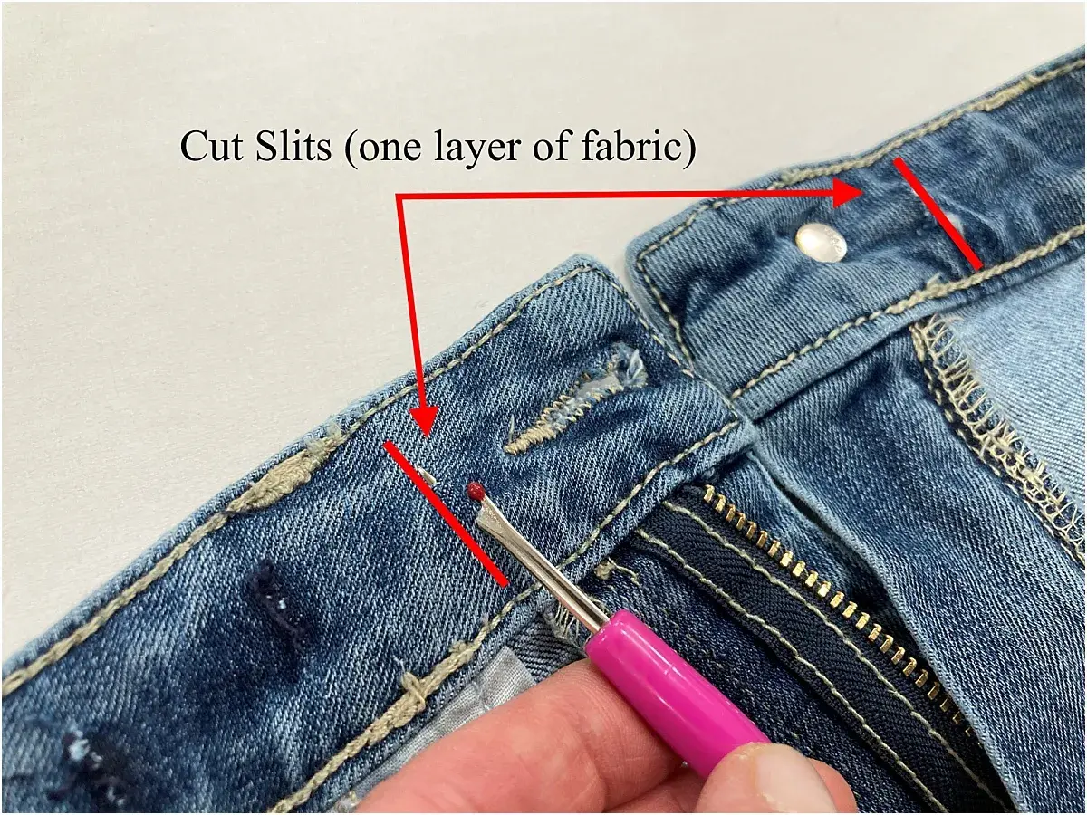 Demonstration of how to take in jeans at the waist by cutting slits in the fabric.