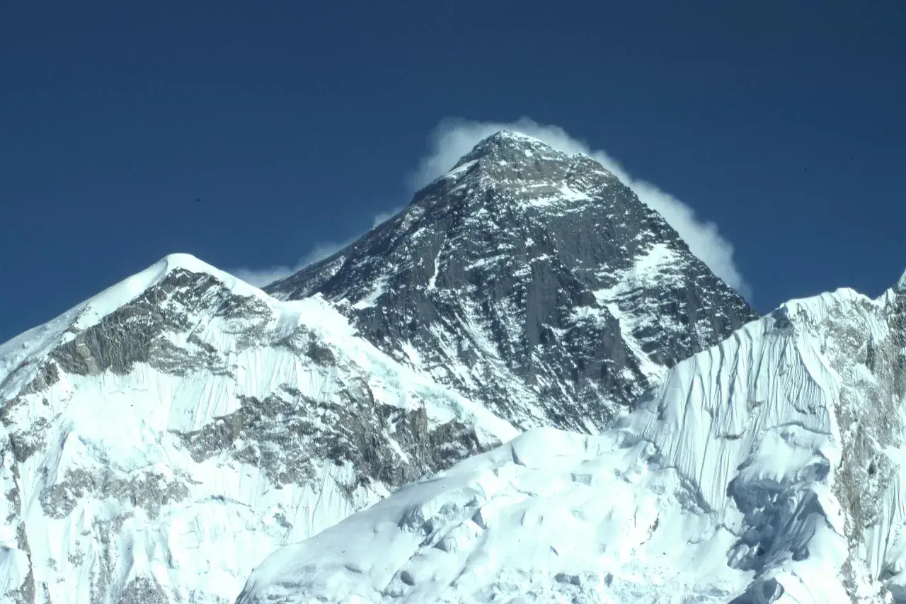 Majestatyczne szczyty pokryte śniegiem, chmury otulające wierzchołek. Widok zapierający dech w piersiach, symbol wejścia na Mount Everest.