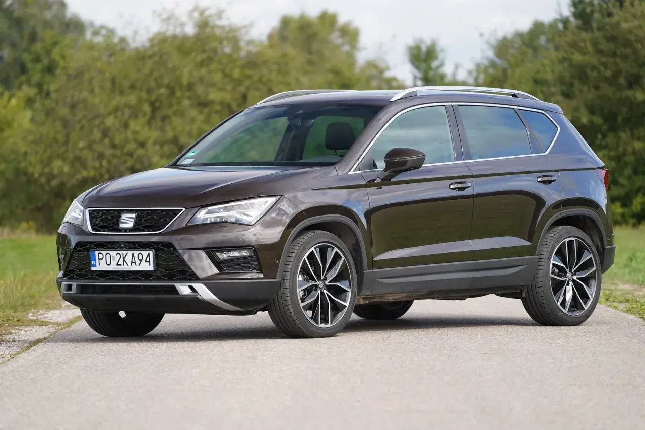Brązowy Seat Ateca na drodze, z widocznymi felgami i detalami nadwozia. Poznaj jego wymiary.