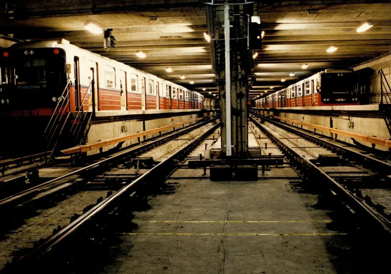 Dwie linie pociągów metra M1 stoją na stacji.