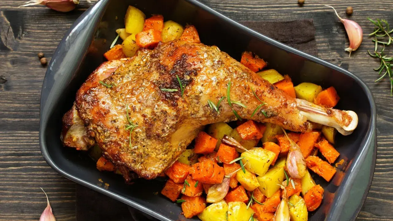 Cuisse de dinde au four, dorée et savoureuse, accompagnée de légumes rôtis et d'ail. Un plat réconfortant prêt à être dégusté.
