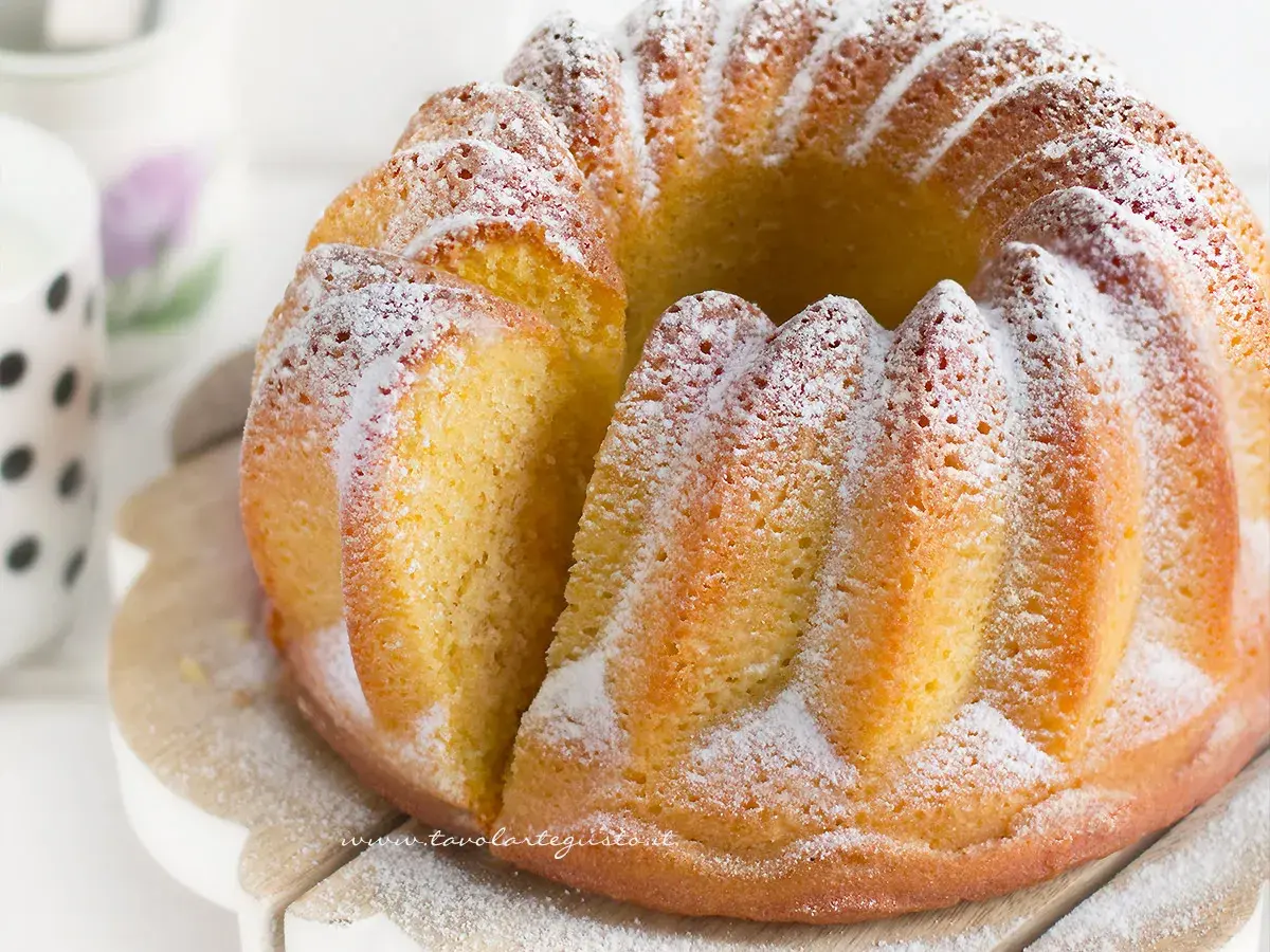 Un soffice ciambellone allo yogurt, spolverato di zucchero a velo, pronto per essere gustato.