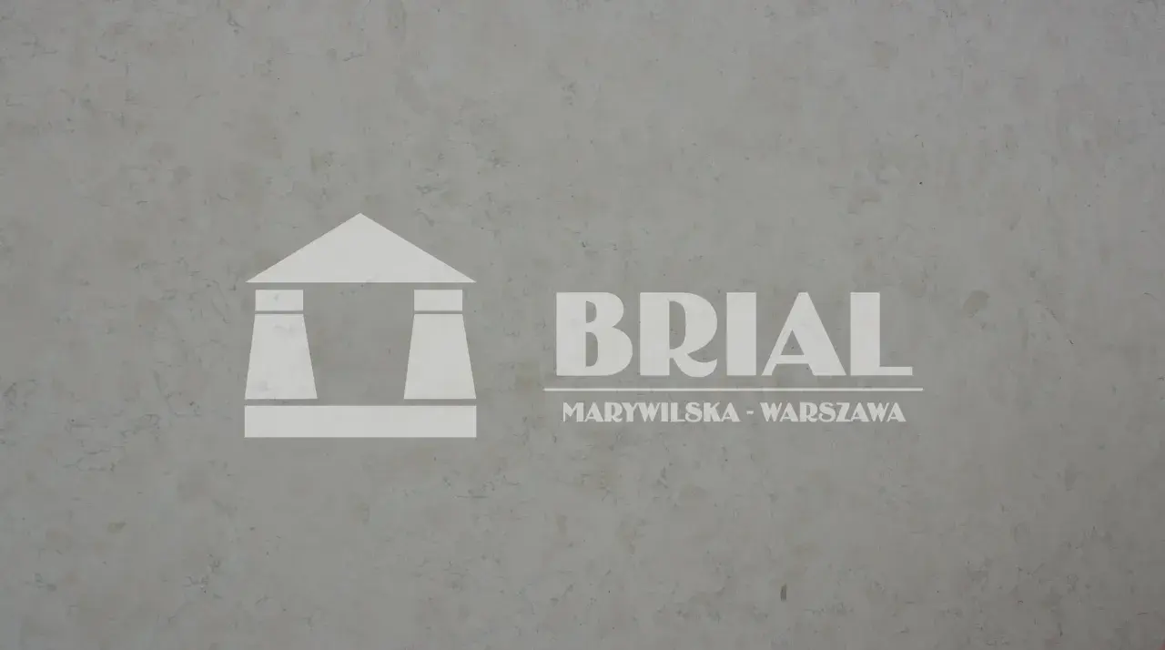 Szary, subtelnie żyłkowany biały marmur włoski z logo BRIAL na tle.