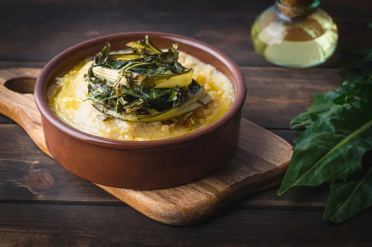 Polenta cremosa con cicoria in padella, un piatto rustico e saporito.