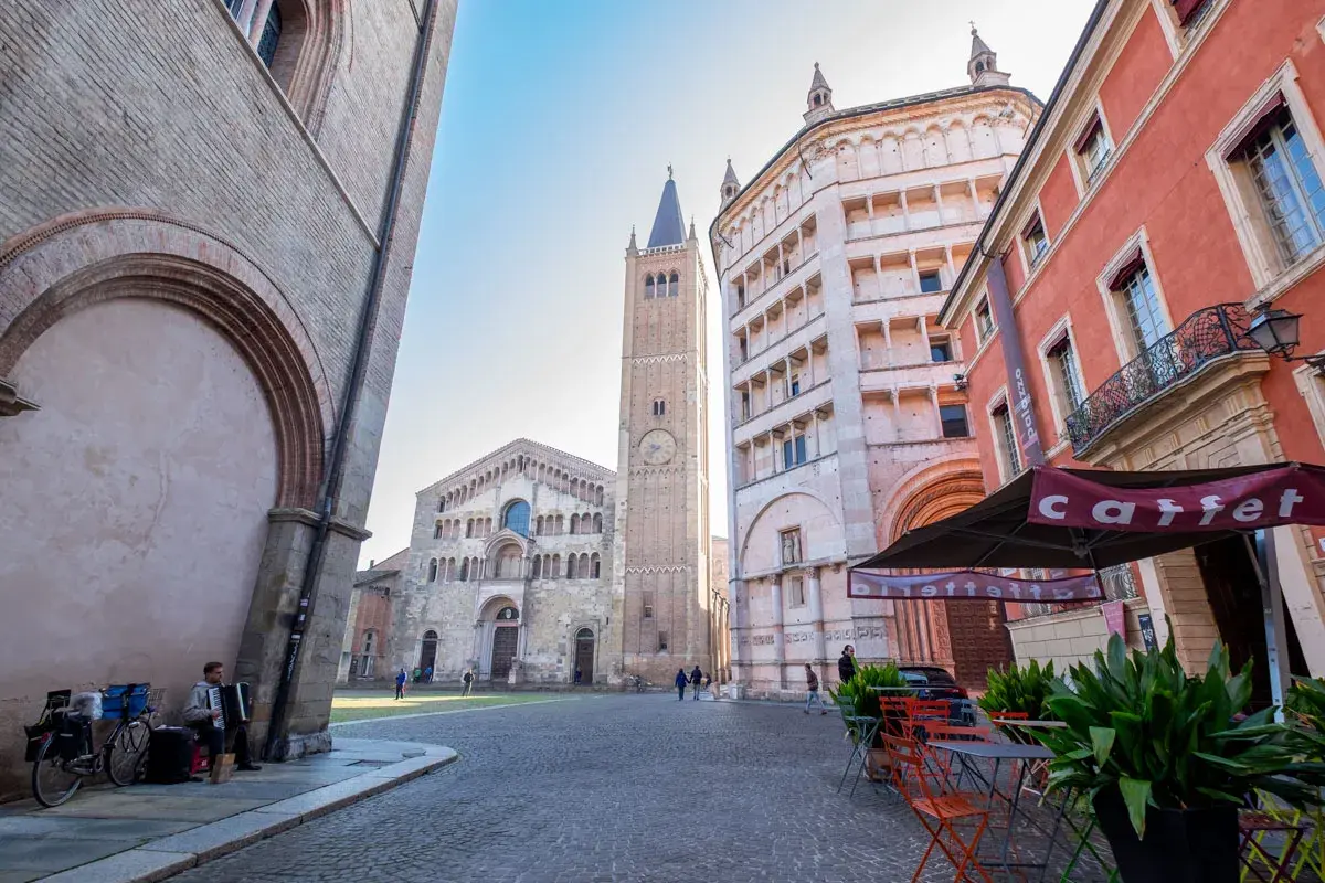 Parma co zobaczyć: Piazza Duomo z katedrą, baptysterium i wieżą. Muzyk gra na akordeonie.
