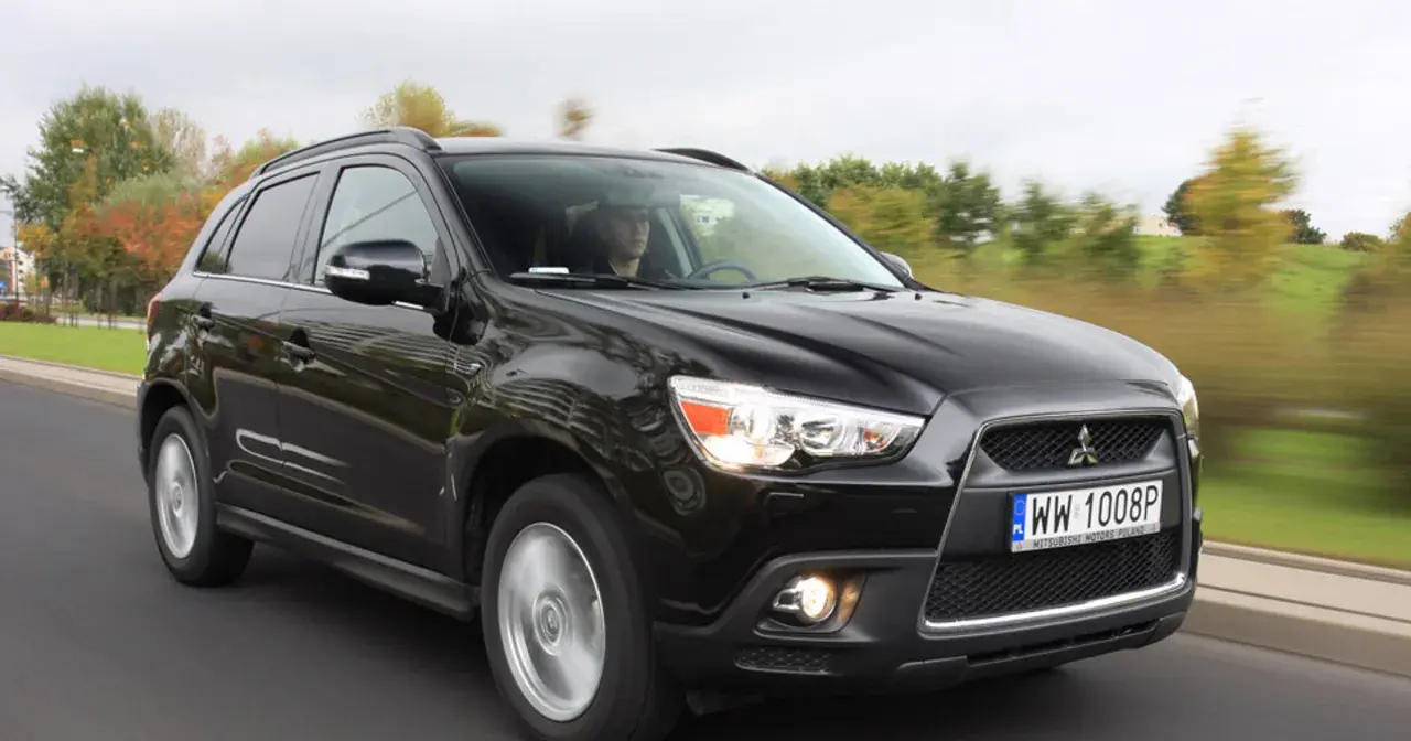 Czarny Mitsubishi ASX 1.6 benzyna w ruchu, z kierowcą za kierownicą.
