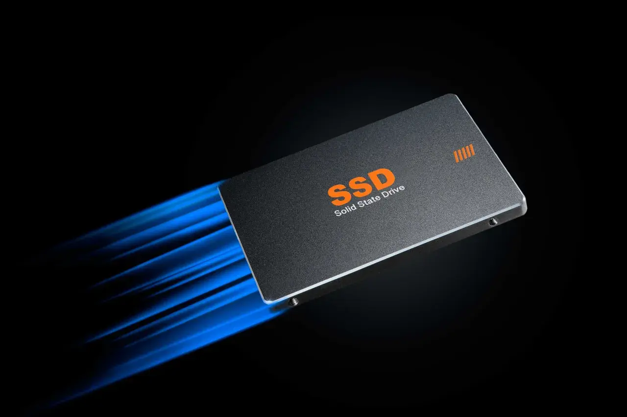 Eine SSD mit orangefarbenem Schriftzug "SSD Solid State Drive" rast mit blauem Lichteffekt, der den **momentum cache** symbolisiert, über einen schwarzen Hintergrund.