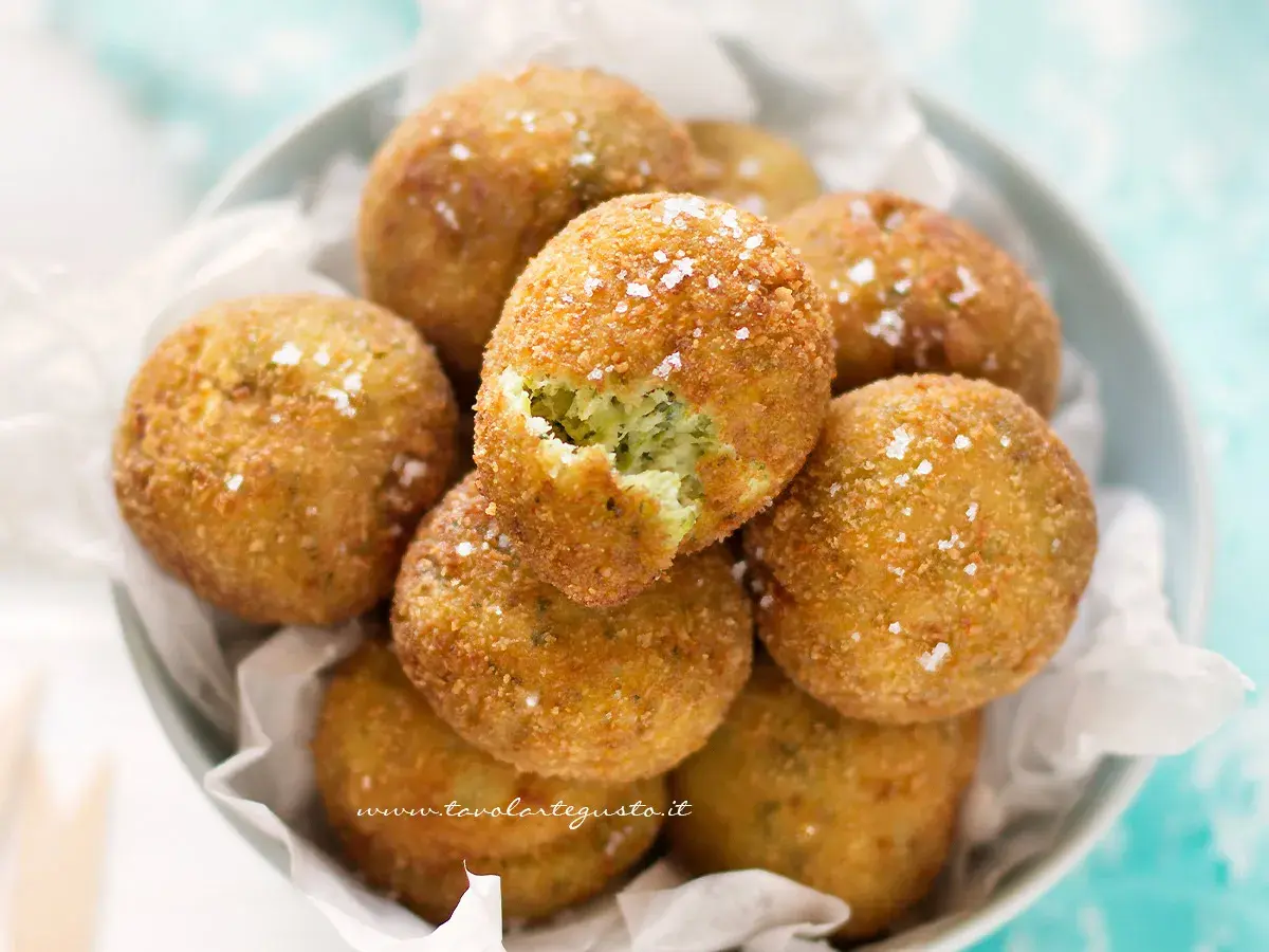 Deliziose polpette di zucchine e ricotta, dorate e croccanti, cosparse di sale grosso.