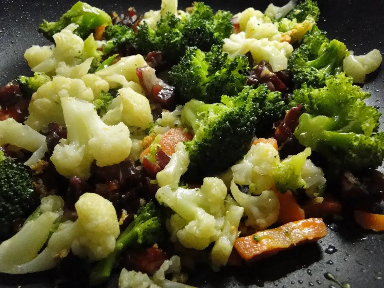 Un panache de verduras salteadas en sartén, con brócoli, coliflor y zanahoria, listo para disfrutar.