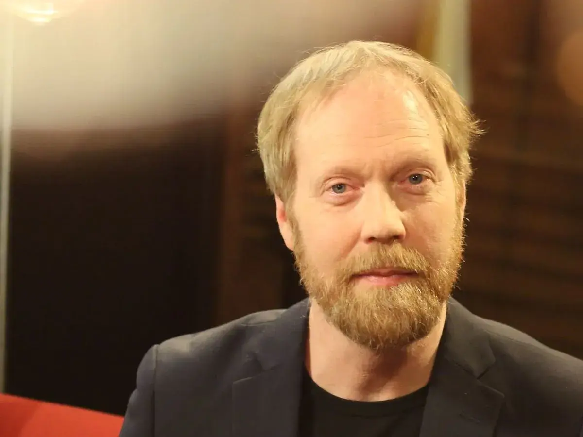 Lars Johan Åge, en man med blont hår och skägg, blickar mot kameran.