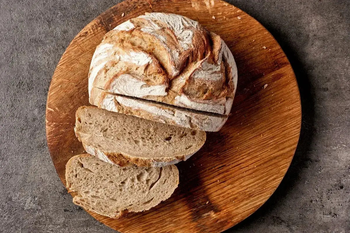 Chleb żytni na zakwasie, pokrojony na desce, to dobry wybór, jeśli szukasz pieczywa, jakie pieczywo ma najmniej kalorii.