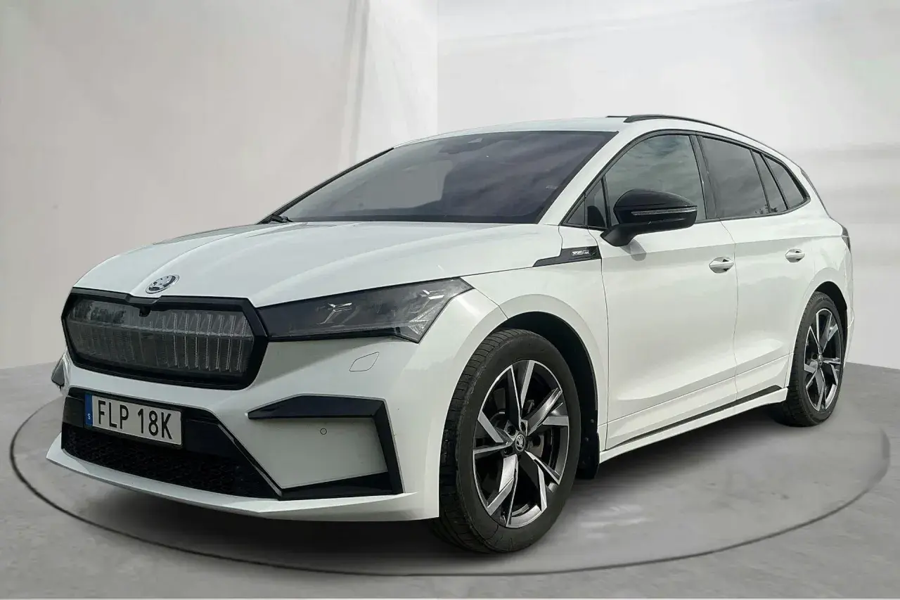 Vit Skoda Enyaq begagnad, en modern elbil med sportig design och snygga fälgar. Perfekt för familjen som söker en hållbar och stilfull transport.