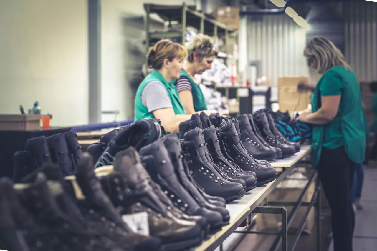 Workers inspect rows of Hanwag boots, hinting at where Hanwag boots are made: a factory floor.