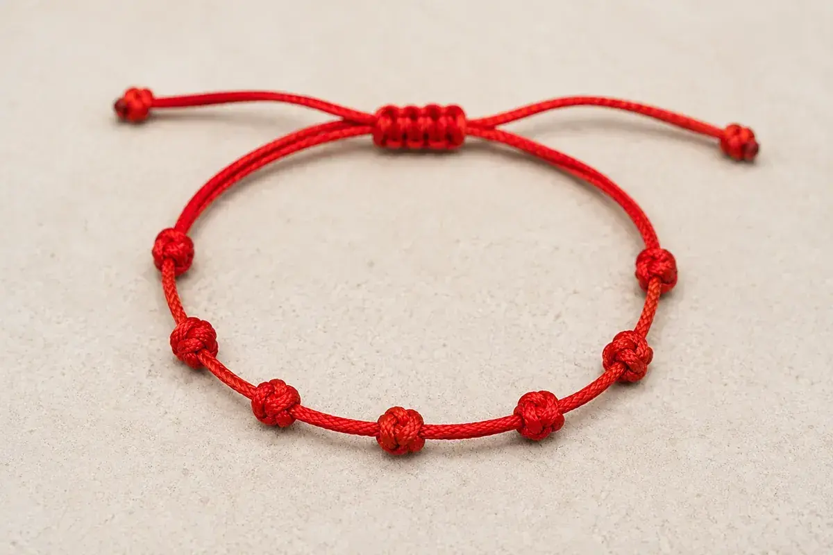 Pulsera roja con siete nudos, cada uno con su propia historia y significado.
