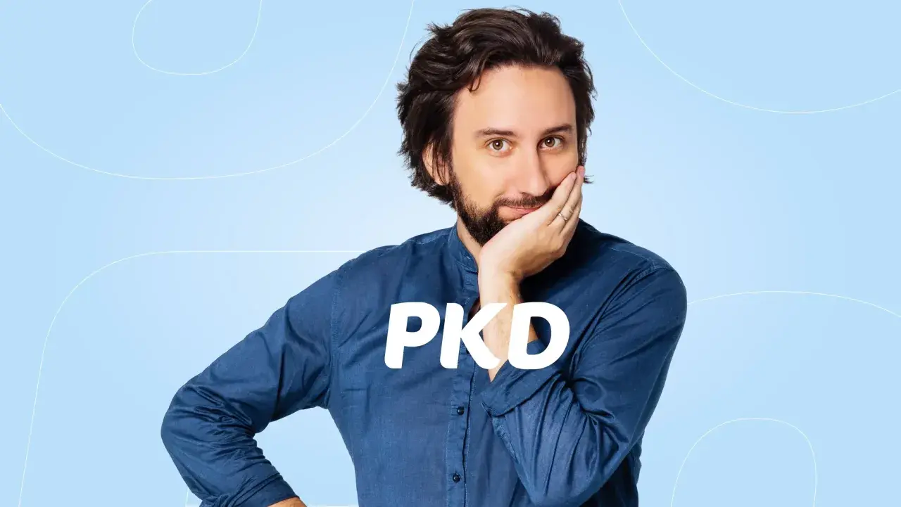 Mężczyzna zamyślony nad tym, jak sprawdzić kody PKD firmy. Napis PKD na jego koszuli.