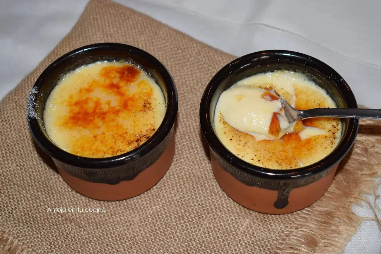 Dos deliciosas cremas catalanas, una con una cucharada lista para disfrutar, sobre una tela rústica.