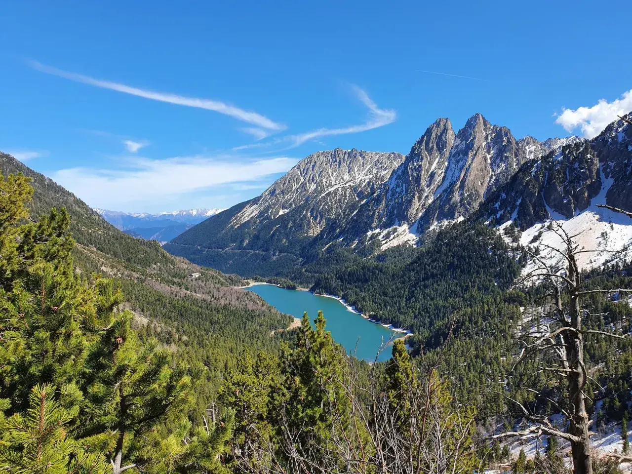 Lago turquesa rodeado de bosques y montañas nevadas, un paisaje espectacular cerca de Esterri d'Àneu.