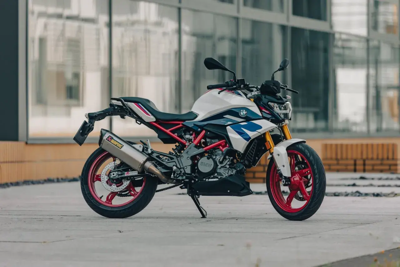 Biało-niebieski motocykl BMW G310R z czerwonymi felgami i wydechem Akrapovič. Poznaj jego bmw g310r dane techniczne.
