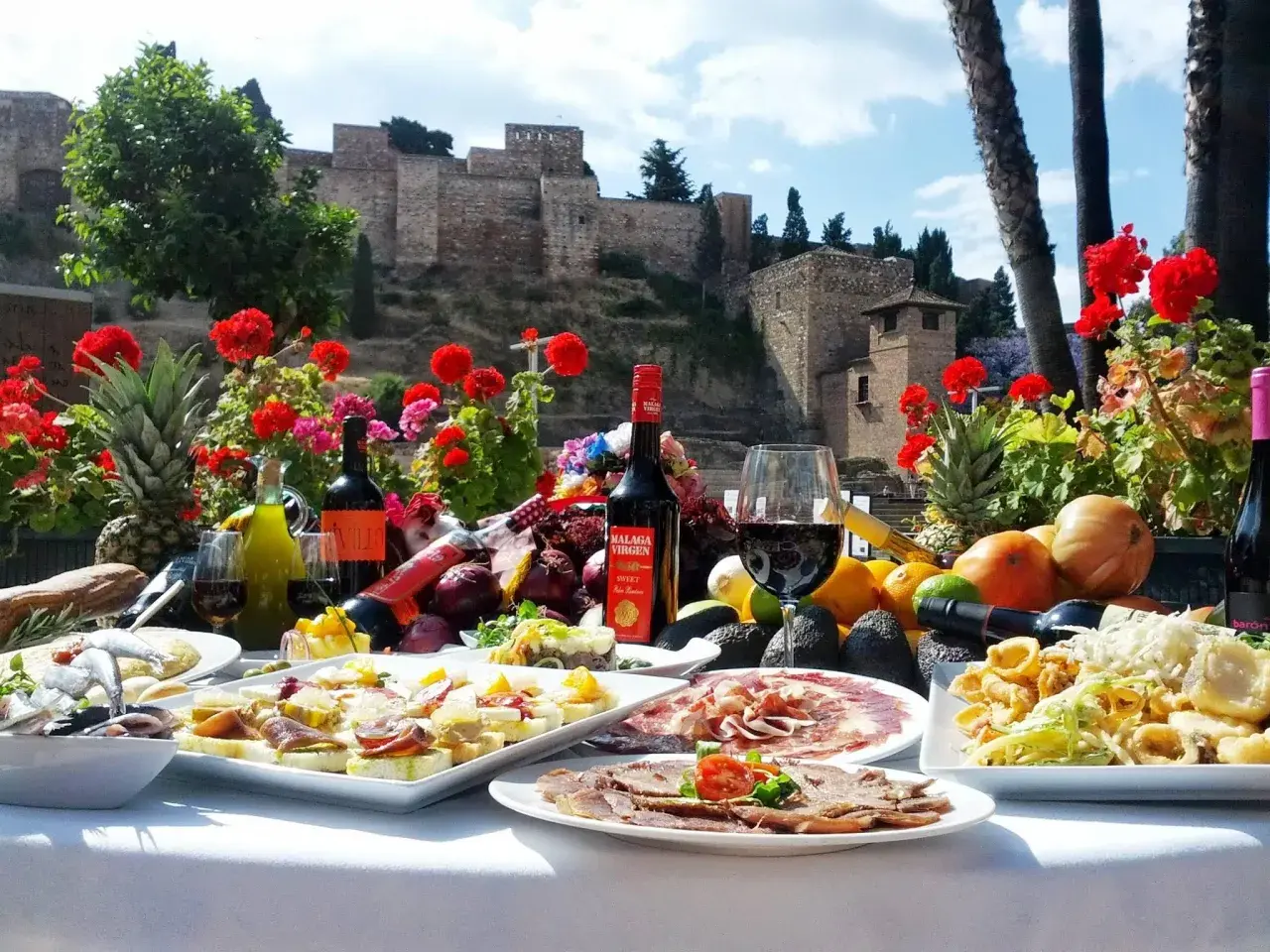 Uczta w jednej z malaga restauracji: tapas, wino i owoce na tle Alcazaby.