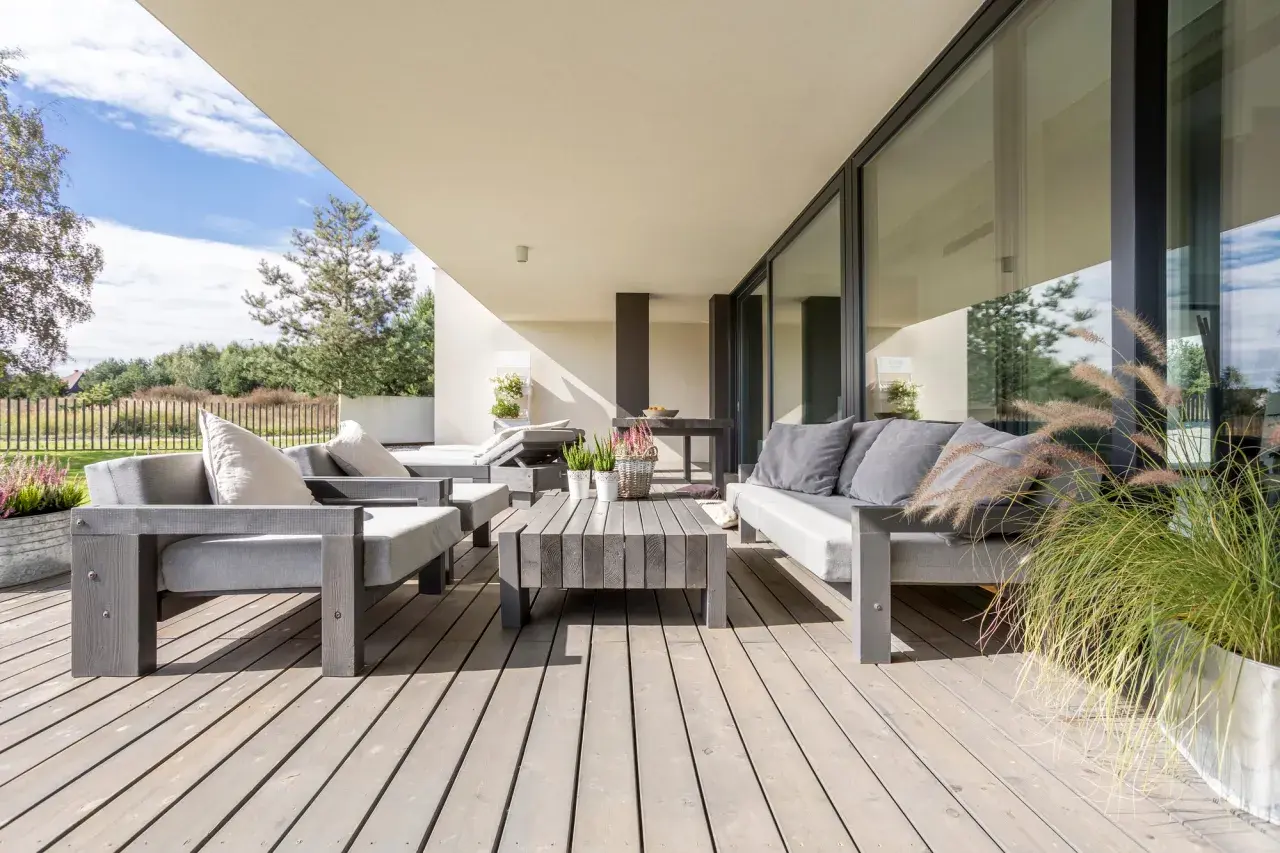 Moderne Lounge-Möbel auf Holzterrasse laden zum Entspannen ein. Perfekt, um die Terrasse gestalten und den Sommer zu genießen.