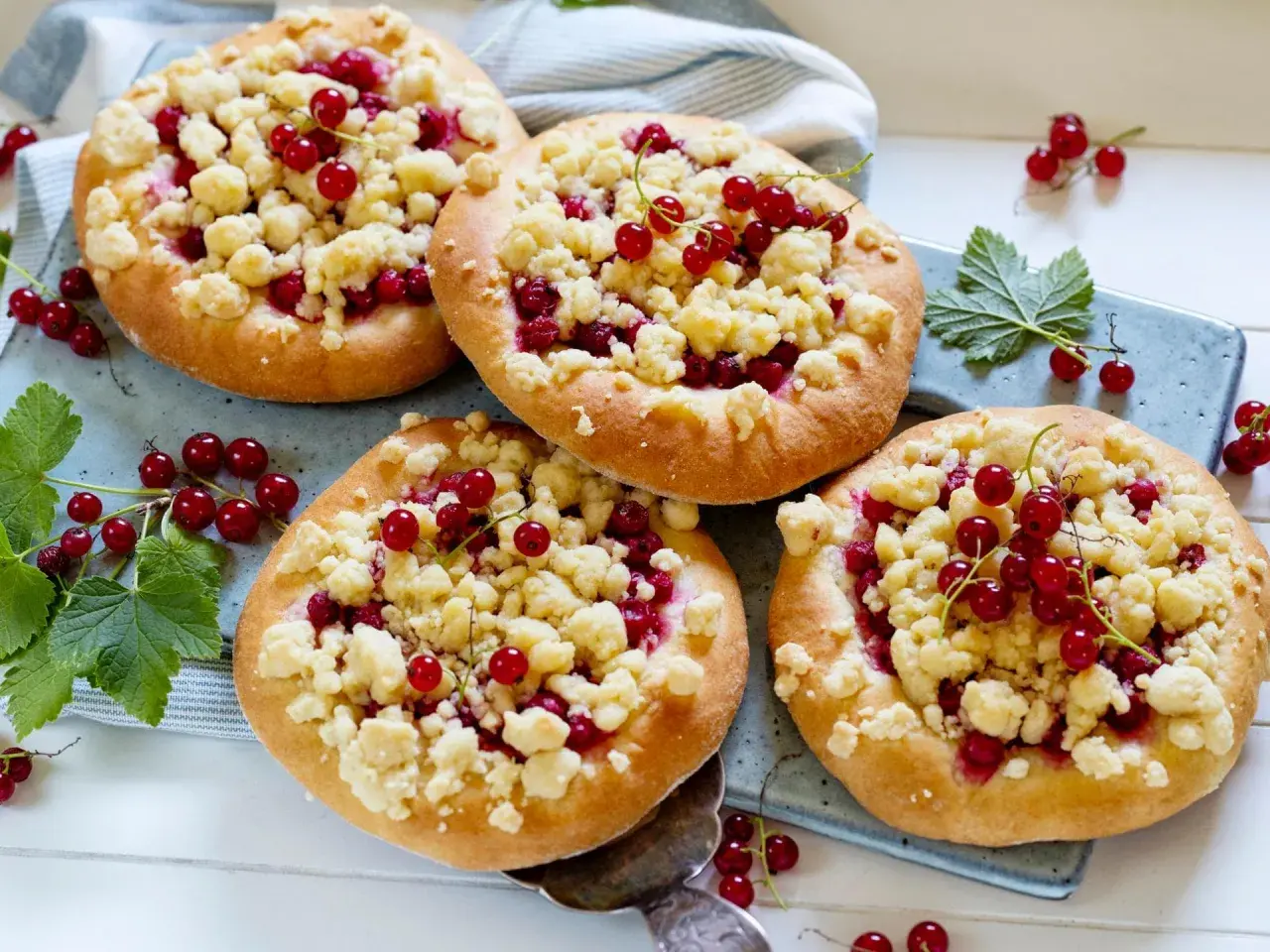 Vier kleine Streuselkuchen mit roten Johannisbeeren, perfekt für Johannisbeer Rezepte.