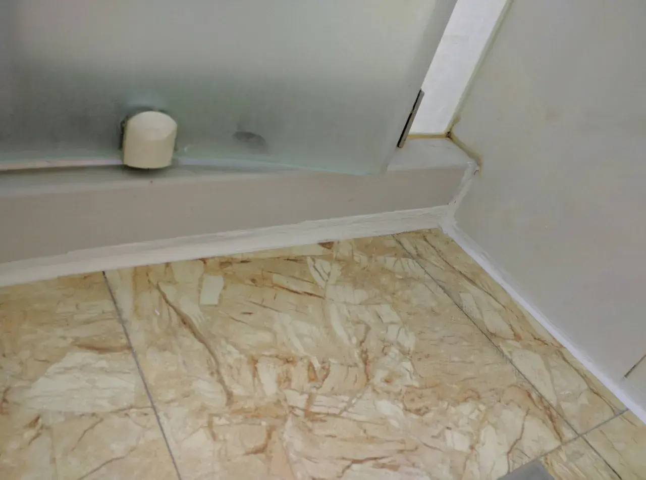 Świeży silikon pod prysznicem, czekający na pełne utwardzenie. Zastanawiasz się, ile musi schnac silikon pod prysznicem, zanim będzie można go używać?