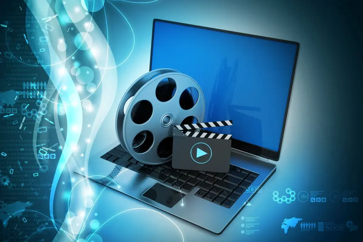 Laptop z kliszą filmową i klapsem, symbolizujące odtwarzanie multimediów. Idealne do obsługi plików dzięki K-Lite Codec Pack.