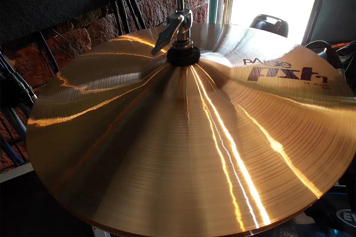 Błyszczące, złote talerze Paiste FX, instrument perkusyjny, odbijają światło, gotowe do rytmicznego uderzenia.